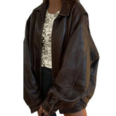 Woman wearing oversized brown leather jacket with floral top and black shorts