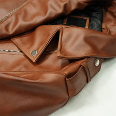 Close-up of brown biker-style women's leather jacket with zipper and snap button details