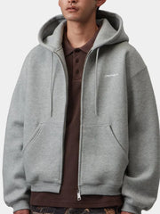 Grey fleece zip hoodie worn open over polo shirt, model front close-up with chest logo