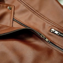 Close-up of women's brown leather jacket with zippers and snap button details