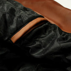 Close-up of a brown leather biker jacket with black quilted lining and an inner pocket.