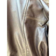 Close-up of brown leather jacket showing smooth texture and detailed stitching