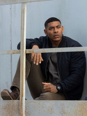 Aaron Pierre John Stewart navy bomber jacket seated industrial scene