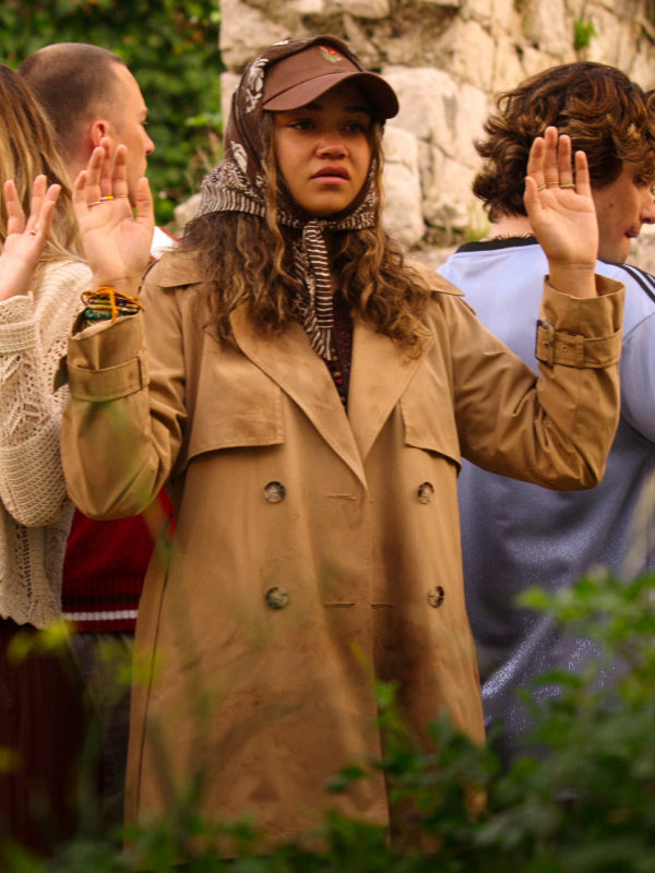 Kiara Carrera Outer Banks Season 5 khaki trench coat hands raised