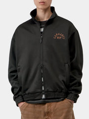 Black fleece jacket with orange embroidered logo, close-up front view