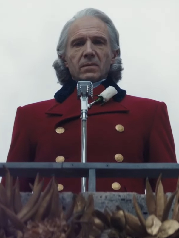 Ralph Fiennes President Snow red coat close up podium