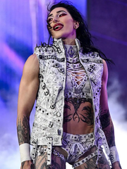 Rhea Ripley wearing white spiked vest close-up, arena entrance moment