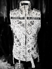 Brutality Asylum Studded white punk vest front view showing spike shoulder detailing, dark backdrop